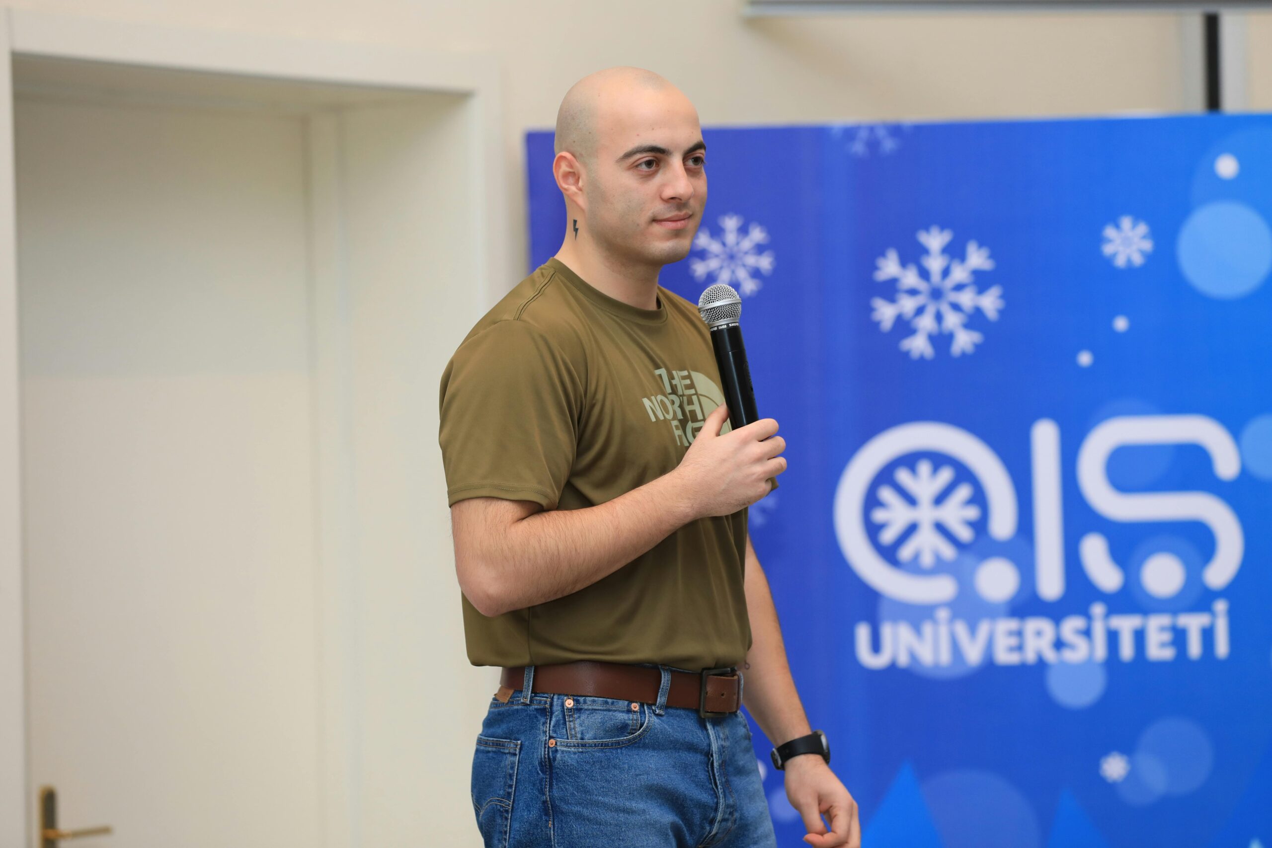 A young man giving a speech at a university event in Baku, Azerbaijan.